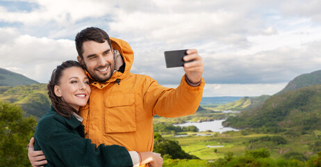 Sticker - technology, travel and travel concept - happy couple with smartphone over river valley at Killarney National Park in ireland on background