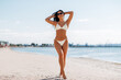 © Syda Productions - people, summer and swimwear concept - happy smiling young woman in bikini swimsuit on beach