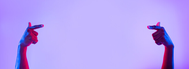 Poster - Unrecognizable young black man pointing at empty space in neon light, banner design