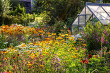 Fototapeta  - Blumengarten im Sonnenschein mit Gewächshaus, Flowering Garden and a Greenhouse