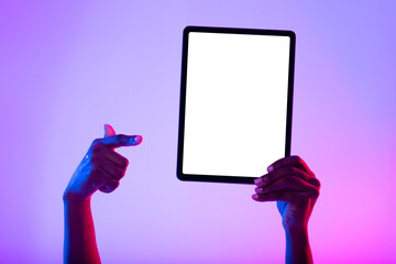 Poster - Unrecognizable black woman pointing at blank tablet, recommending new app, advertising website in neon light, mockup