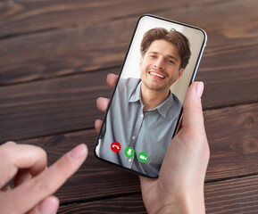 Cropped of woman having video conference with boyfriend, holding smartphone with guy photo on screen, collage