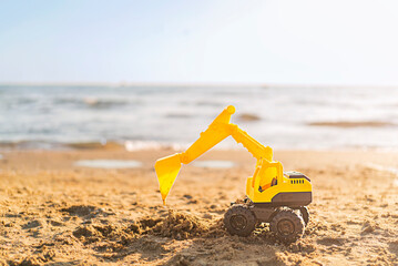 toy excavator on the beach with copy space