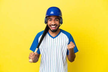 Poster - Young Colombian latin man playing baseball isolated on yellow background celebrating a victory in winner position