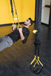 © LIGHTFIELD STUDIOS - Muslim sportsman training with suspension straps in gym.