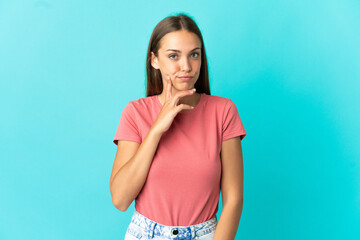 Young woman over isolated blue background and thinking