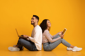 Wall Mural - Online Entertainment. Happy Middle Eastern Couple With Laptop And Digital Tablet