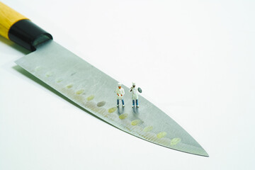 Sticker - chefs standing on a kitchen knife on white background. Top view