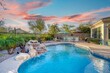 canvas print picture - Luxury home pool at sunset with a waterfall