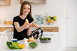 © rostyslav84 - Young beautiful vegetarian girl dressed in pajamas eating fruits and vegetables for breakfast at home in the kitchen