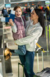 © NFstock - Ready to the flight. Vertical view of the overjoyed mother and daughter rejoicing of the future travel. Girl holding passports and tickets and looking at the camera