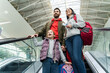 © NFstock - Wow. Low angle view of the overjoyed little baby standing at the moving staircase with her parents and looking with admiration at something