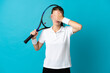 © luismolinero - Young woman tennis player isolated on blue background covering eyes by hands. Do not want to see something