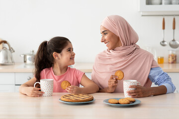 Wall Mural - Portrait Of Happy Islamic Family Mom And Daughter Eating Snacks In Kitchen