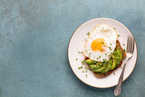 Fototapeta  - Keto breakfast fried egg, avocado and bread in a white plate. Keto diet concept.