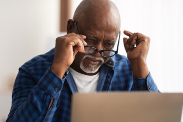 Wall Mural - Senior Black Man Squinting Eyes Taking Off Eyeglasses Indoor