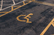 © Jakub Pabis - Disabled parking. Accessible parking spot. Blue badge. Yellow wheelchair sign on the ground