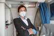 © Kostiantyn - Woman flight attendant in medical mask standing in airplane