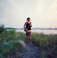 Wall Mural - Young man dressed for summer at waterfront