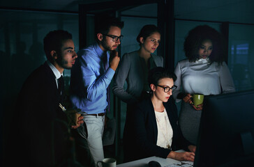 Gather round everyone. Cropped shot of a diverse group of businesspeople gathered around a single computer in their office.