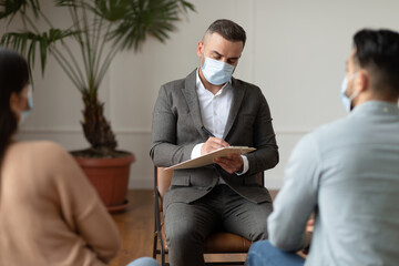 Wall Mural - Couple having therapy session with therapist, man writing