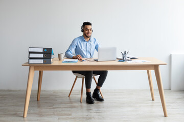 Aufkleber - Arab man using laptop wearing headset sitting at desk