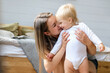 © Oksana - Young happy mother hugging and kissing baby. High quality photo