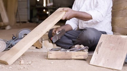 Wall Mural - Close up hands of Carpenter busy working by using block plane for removing rough surfaces on wood at shop - concept of artisans, self employed and skilled labour