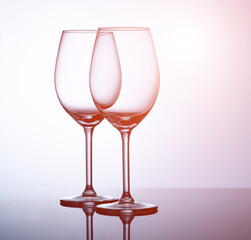 two glass goblets on a mirror surface