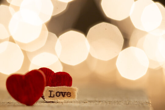 Valentine's Day greetings concept. Little red wooden heart and text Love close up. Valentines greeting card.
