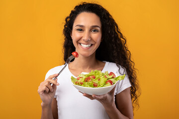 Portrait of Smiling Latin Lady Holding Plate With Salad