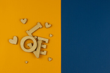 Wall Mural - Love word, small hearts on colorful paper background. Top view of Valentine's Day.