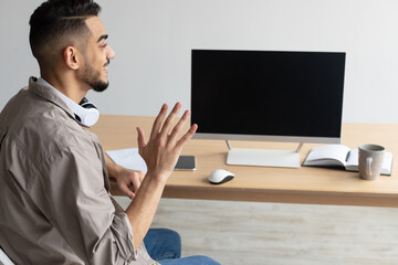 Wall Mural - Arab man waving hand at blank empty computer monitor