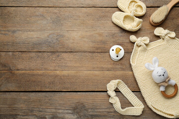 Wall Mural - Cute baby stuff on wooden background, flat lay. Space for text