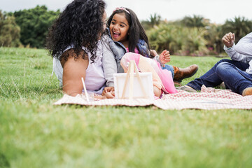 Poster - Happy indian family having fun painting with children outdoor at city park - Mother day concept - Main focus on female kid face