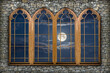 © tillottama - A night-time backdrop. Four windows in a grey stone wall overlooking the night sky with clouds and the moon