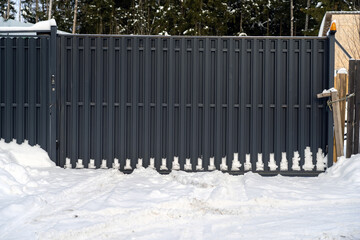 typical suburban gateway with snowbanks during winter. Counryside parking gate in winter during snowfall