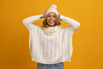 Wall Mural - young smiling happy pretty blond woman wearing white knitted sweater, scarf and hat