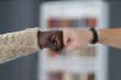 © Svyatoslav Lypynskyy - Young friends making a fist bump with shelf background. People do a fist pump together after good deal. Quarantine greetings. Man giving fist bump. Brotherhood unity bump