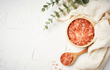 top view Himalayan salt raw crystals in wood spoon and bowl on white table background with copy space                                                                                         