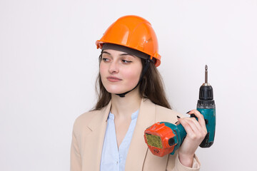 Girl engineer in an orange construction helmet with a screwdriver and a hammer on a white background.