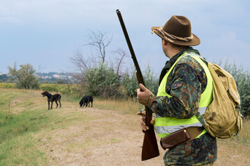 Wall Mural - Hunter man in camouflage with a gun during the hunt in search of wild birds or game. Autumn hunting season.