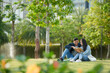 © DragonImages - Young university students reading book for class together when sitting on grass on campus