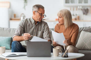 Wall Mural - Senior Couple Holding Papers Reading Documents Sitting At Laptop Indoor