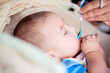 © Cavan Images - Baby being fed first solid meal with a blue spoon.