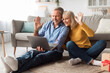 © Prostock-studio - Senior Couple Video Calling Waving Hello To Laptop At Home