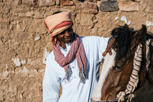 Smiling Egyptian Man Stroking Horse In Village