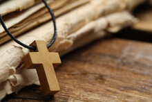 Wooden Christian Cross And Old Bible On Table, Closeup. Space For Text