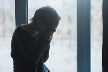 Sad stressed woman sitting alone suffering, crying, broken heart and mental health concept