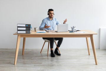 Aufkleber - Arab man using laptop wearing headset making video call